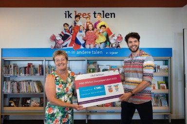 Toos van den Beuken krijgt de prijs uitgereikt door Joran Floor van de BiebBoys, de Jeugdspecialisten van 2021.